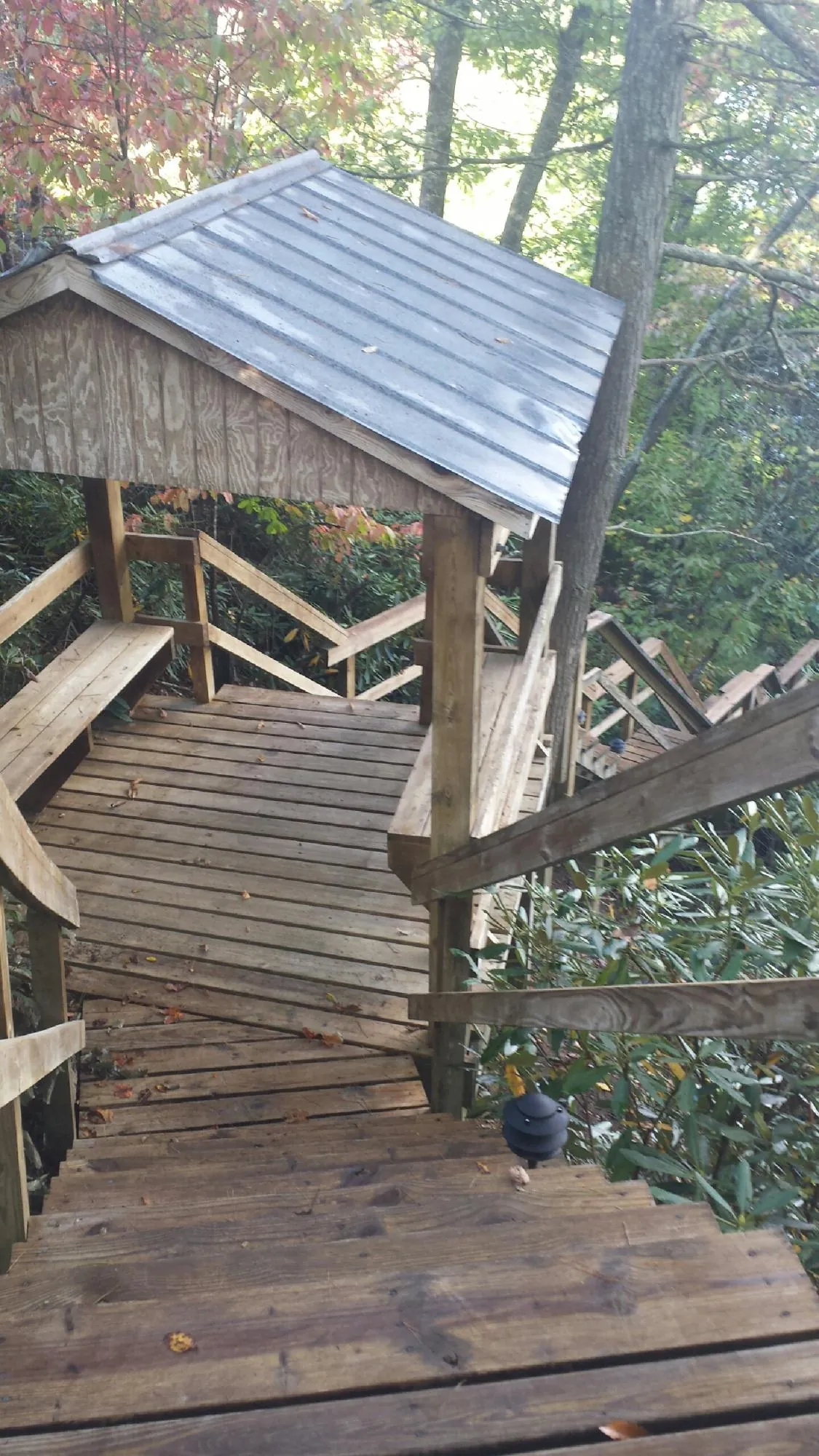 Metal roofed shelter over wooden steps on a wooded walkway — Skylight Repair & Installation work by our crew in Norwich